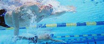 Two competitive swimmers racing in a swimming pool underwater view