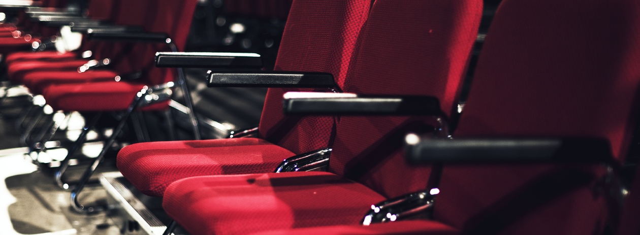 Background image of dark red chairs, some not in focus, on purpose